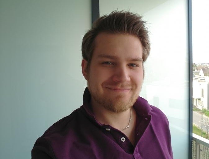 Ein Mann mit kurzem Haar und einem Lächeln