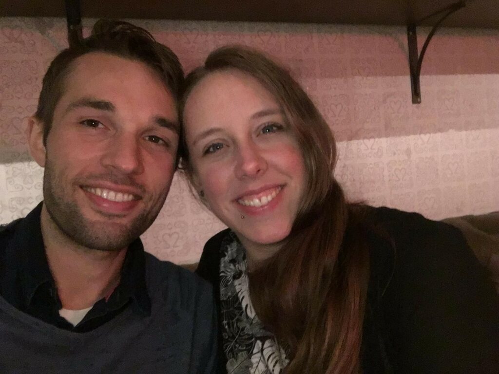 Ein Mann und eine Frau lächeln in die Kamera. Sie sind zusammen und strahlen Freude aus.