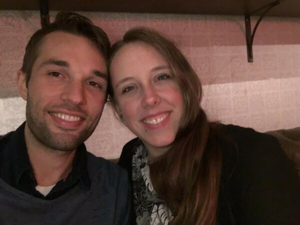Ein Mann und eine Frau lächeln in die Kamera. Sie sind zusammen und strahlen Freude aus.